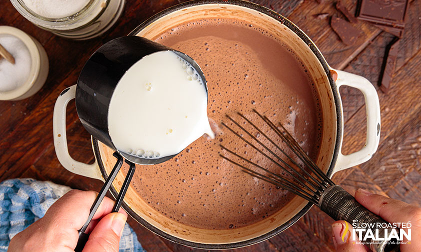 adding milk to saucepan of melted chocolate.