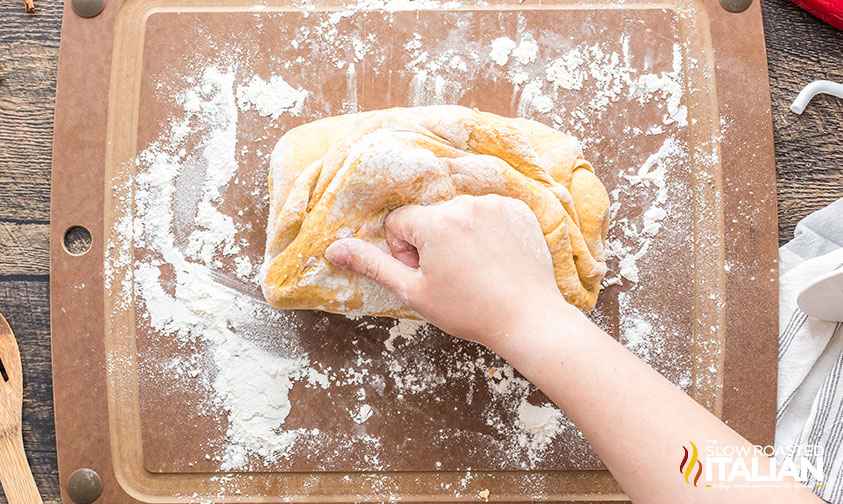 kneading dough for pumpkin dinner rolls.