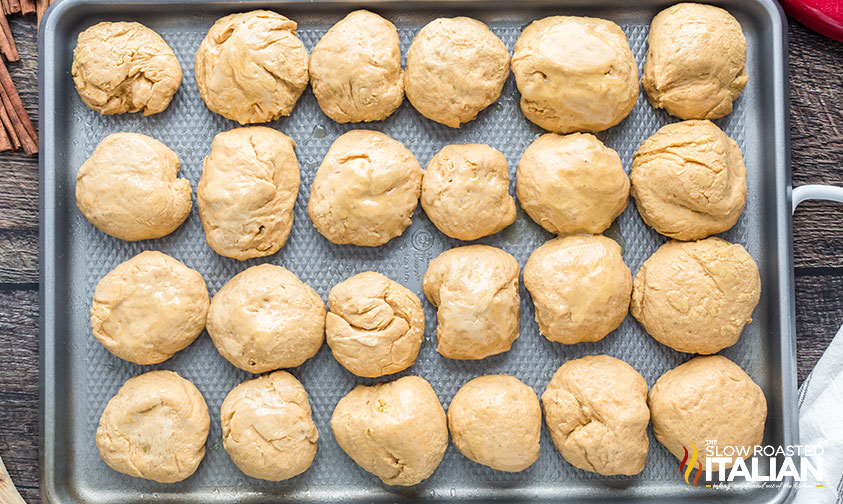 pumpkin bread rolls on baking sheet.