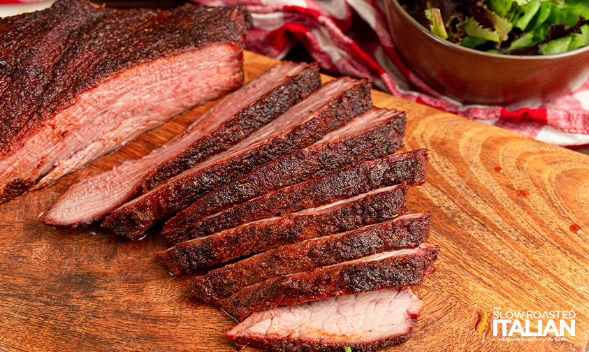 sliced smoked roast beef on cutting board.