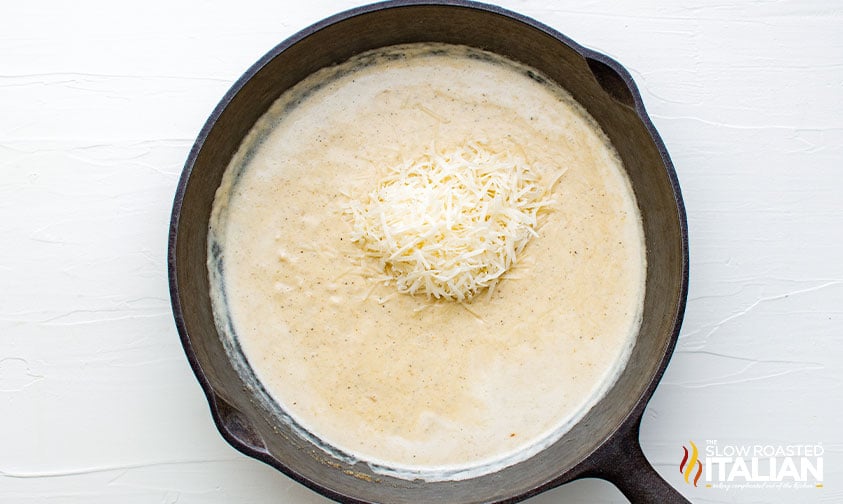 adding parmesan cheese to skillet.