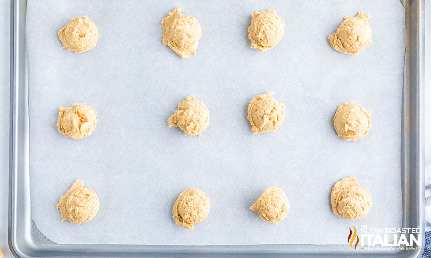 scoops of white chocolate macadamia cookie dough on baking sheet.