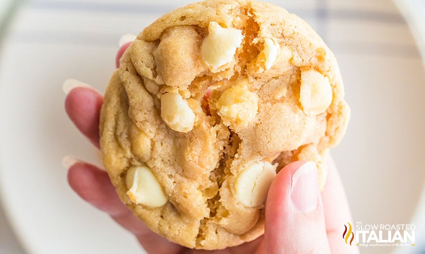 hand holding white chocolate macadamia cookie.