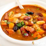 bean soup in white bowl with spoon.