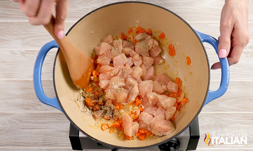 adding chicken to the pot.