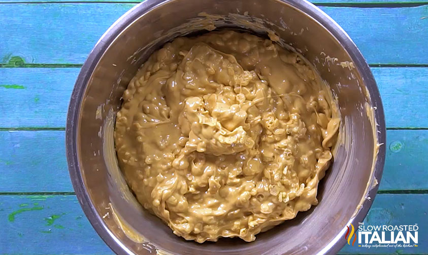 mixing peanut butter and rice krfispies.