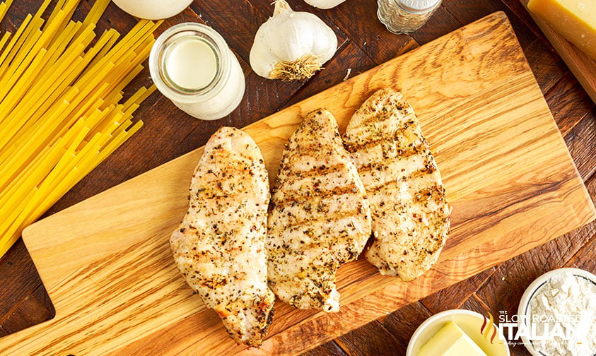 cooked chicken breasts on wood board