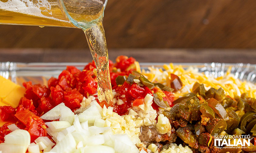 pouring beer into queso ingredients.