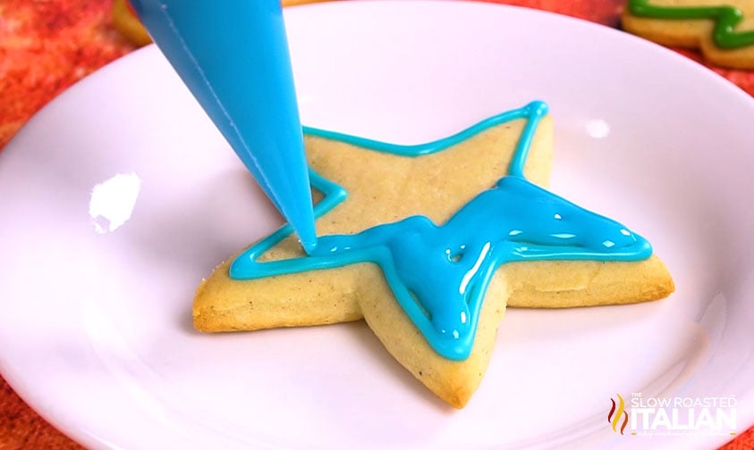 flooding sugar cookie with icing.