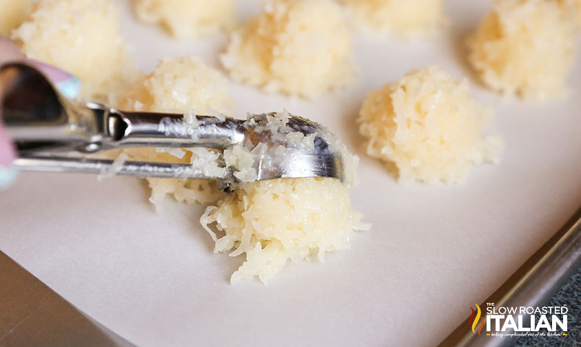 scooping coconut cookies onto sheet pan