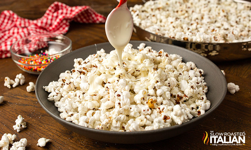 adding white chocolate to popcorn.