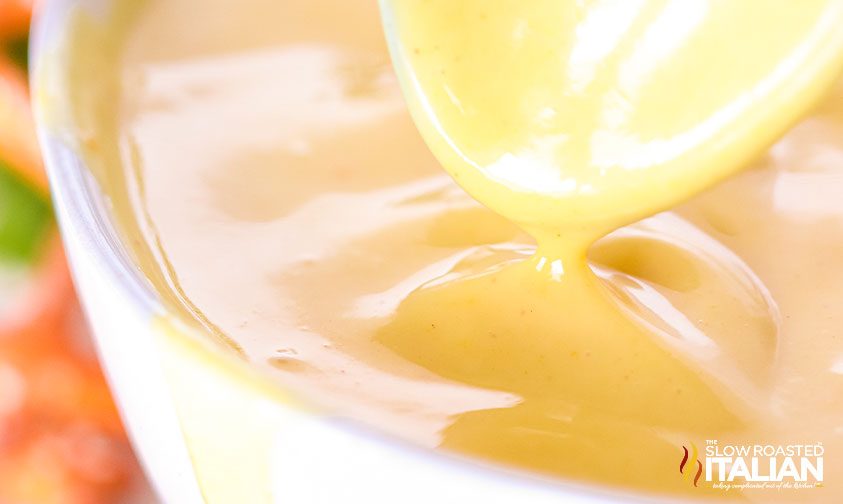 honey mustard sauce dripping from spoon into bowl