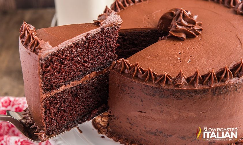 serving slice of super moist chocolate cake with chocolate frosting