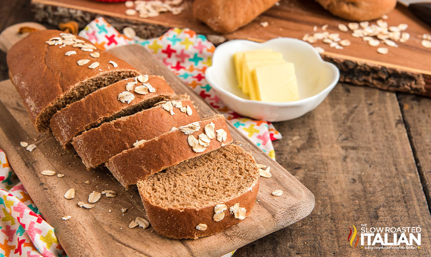 sliced loaf of Cheesecake Factory brown bread with a bowl of butter