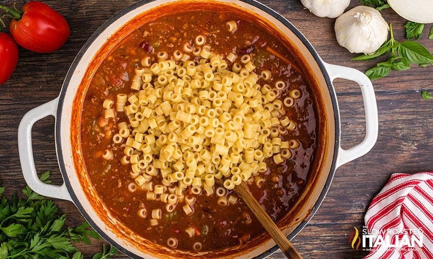 stirring pasta into pot of olive garden pasta fagioli soup