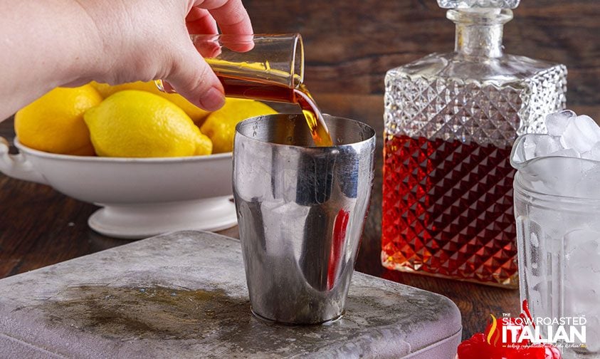 pouring amaretto into a cocktail shaker