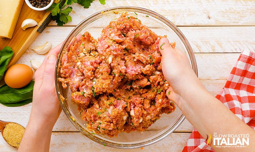 hands combining ground beef mixture in a bowl