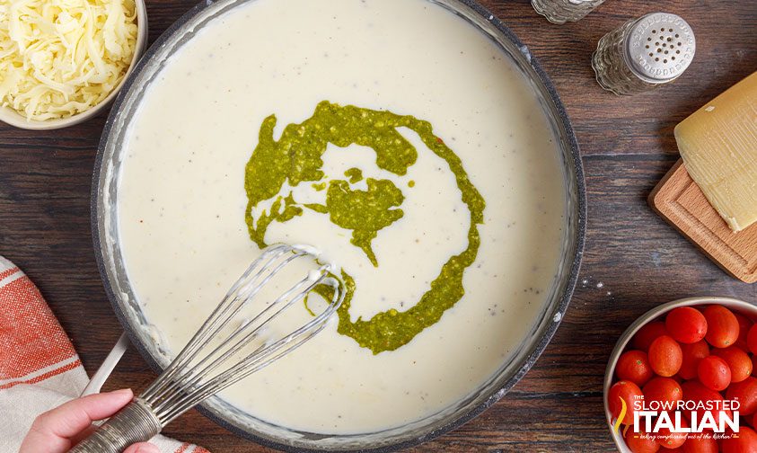 whisking pesto into cream sauce