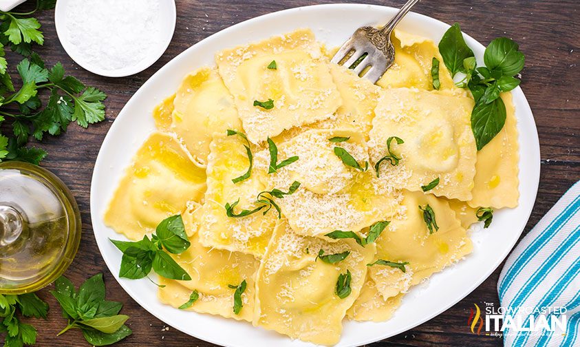 platter of homemade ravioli topped with parmesan and basil