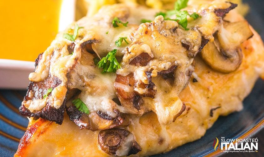 close up: baked chicken smothered in bacon, cheese, and mushrooms