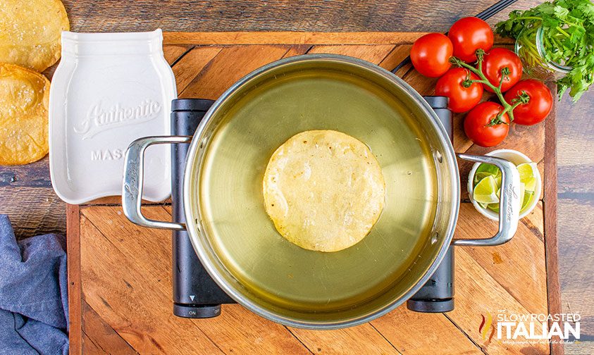 overhead: fried tortilla in pot of oil