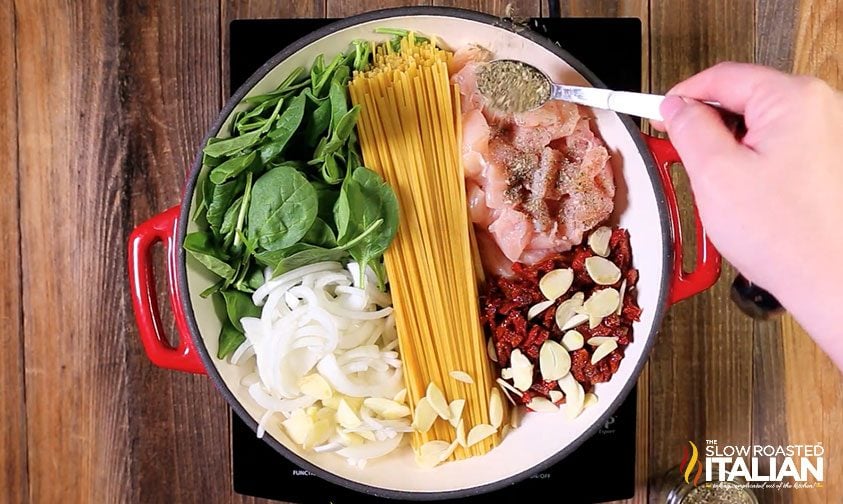 ingredients for cheesy chicken pasta in a dutch oven