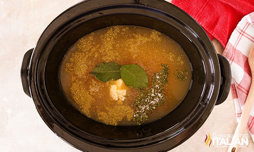 chicken, broth, herbs and spices in a cooking pot