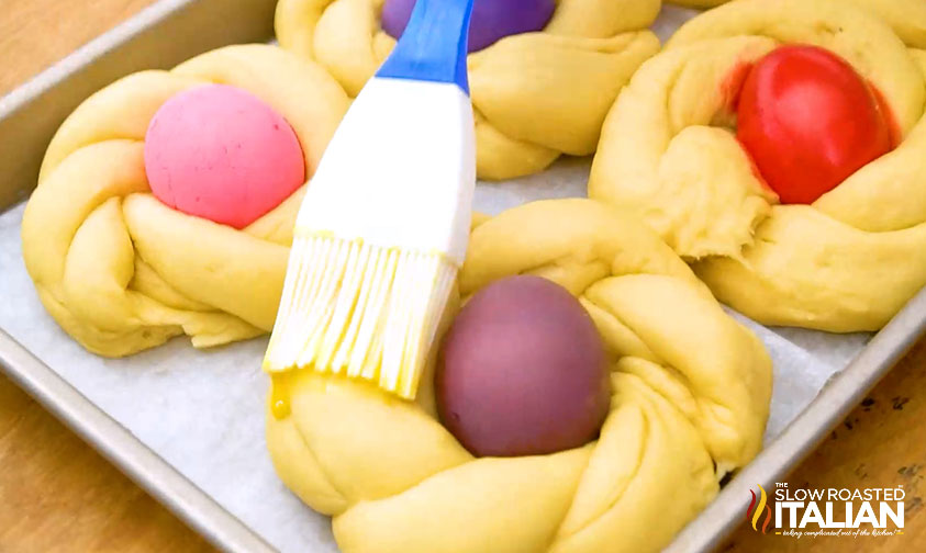 brushing egg wash onto braided easter dough