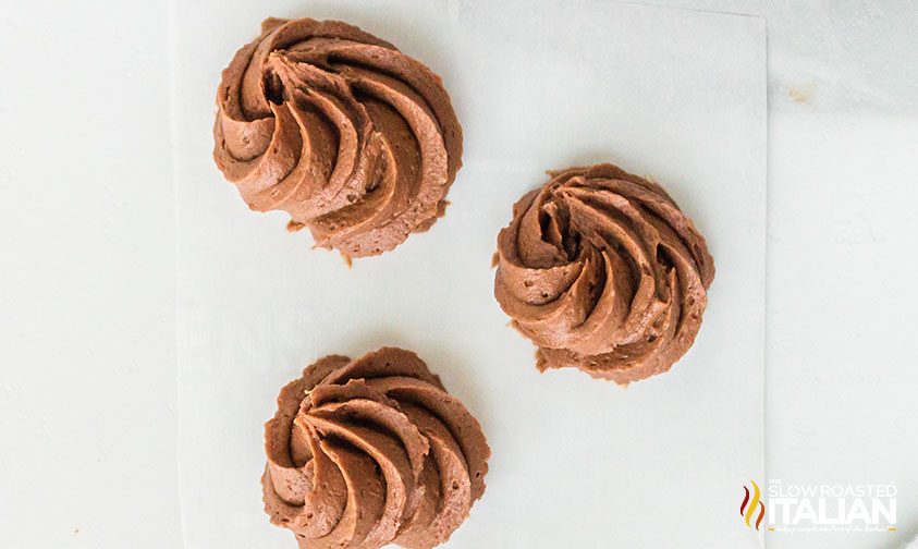 overhead: fluffy chocolate frosting piped onto cupcakes