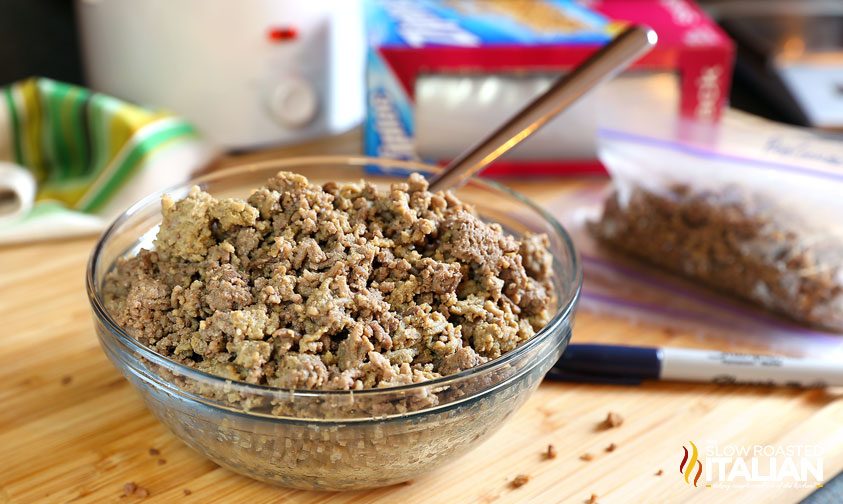 bowl of cooked ground beef with meal prep containers in the background