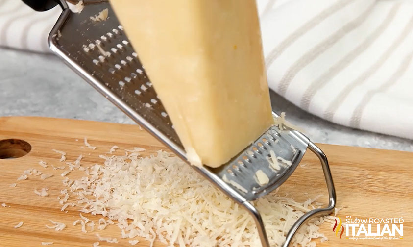 grating a wedge of parmesan cheese