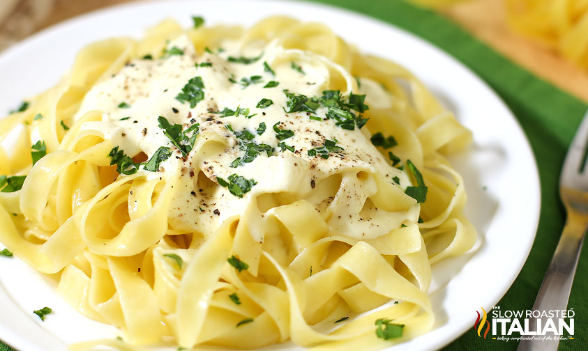 plate of pasta topped with olive garden alfredo sauce and parsley