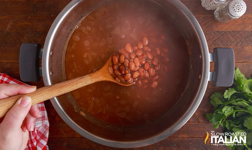 stirring pinto beans in pressure cooker