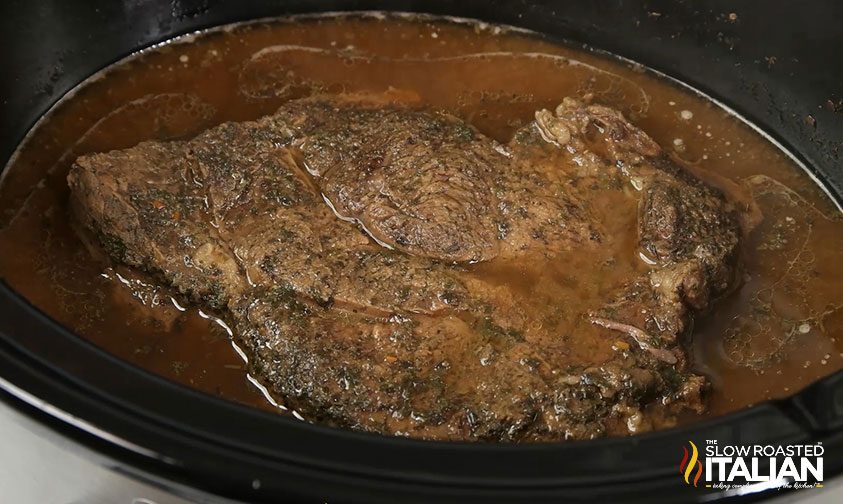 cooked beef roast in slow cooker with juices
