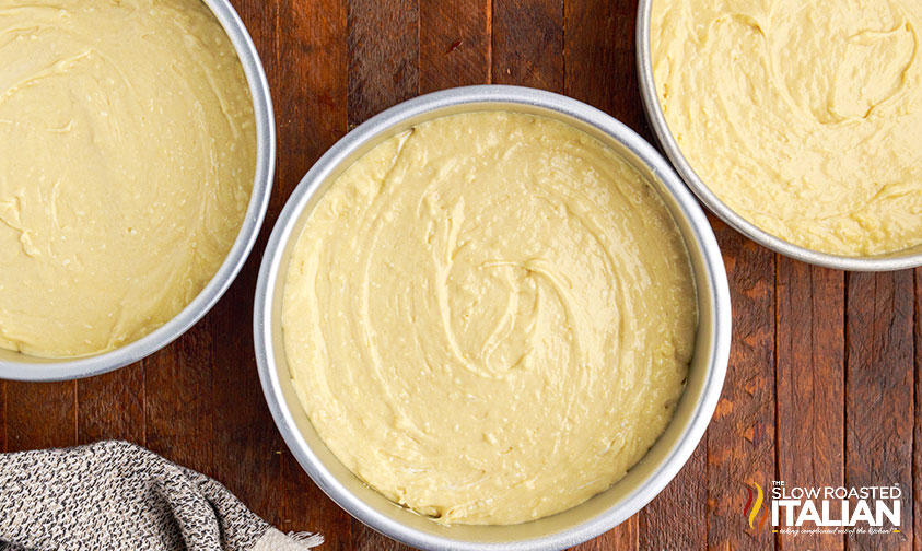 3 round cake pans filled with batter