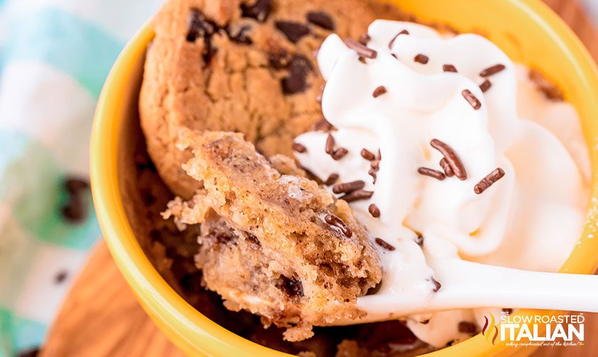 scooping chocolate chip cookie mug cake out of cup