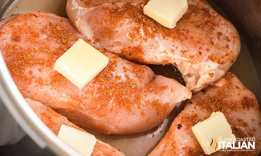 frozen chicken in instant pot topped with spices and butter