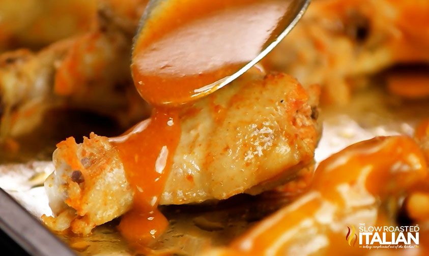 spooning sriracha wing sauce over wings