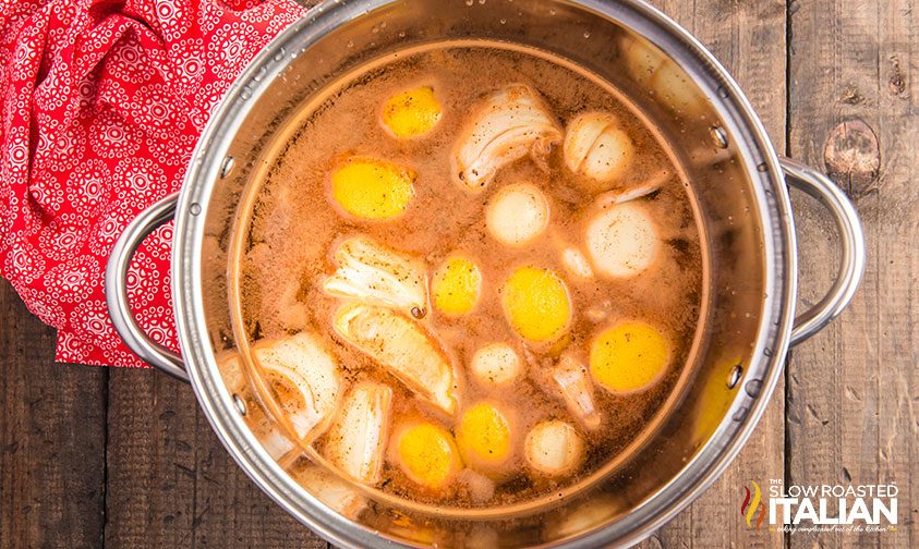 pot of seasoned water, lemons, and onions