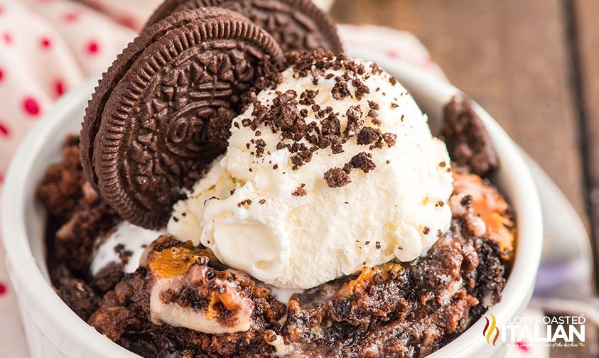 oreo dump cake in ramekin topped with ice cream and cookies