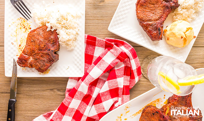 plates with smoked pork chops and rice on table
