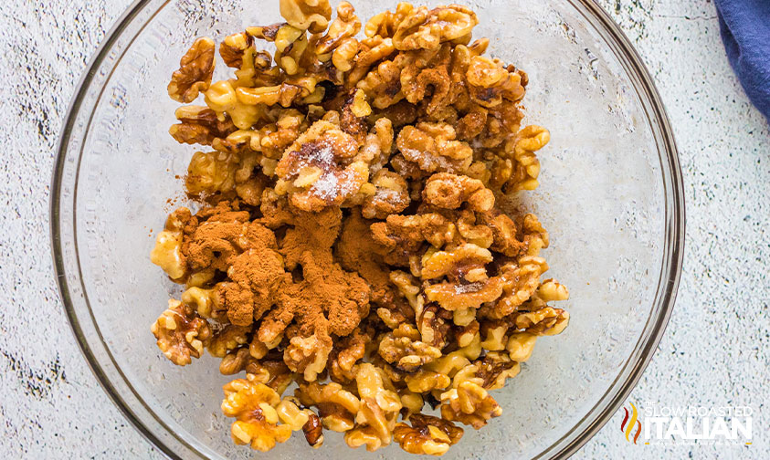 bowl of walnuts topped with maple syrup and spices