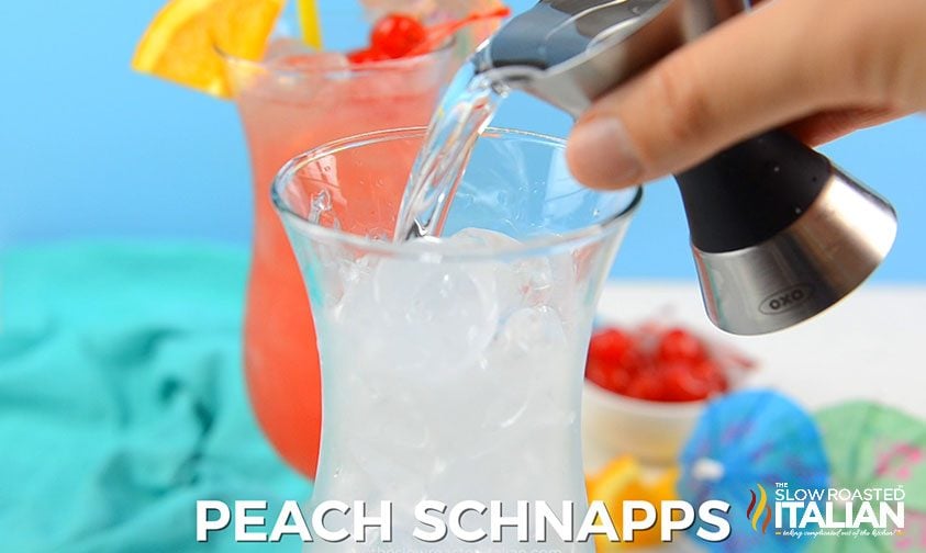 pouring peach schnapps over ice in hurricane glass