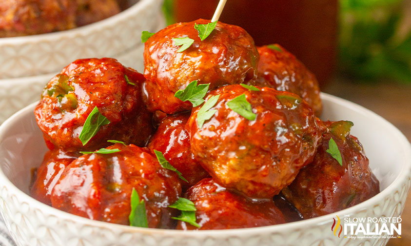 bowl of saucy meatballs garnished with parsley