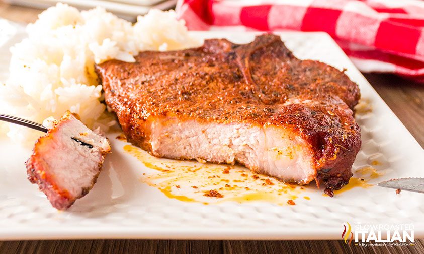 slice removed from smoked pork chop on plate