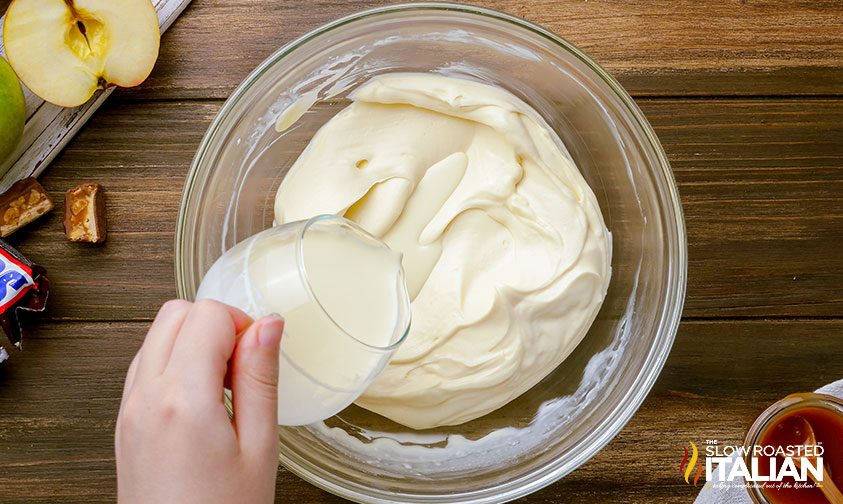 pouring heavy cream into whipped cream cheese