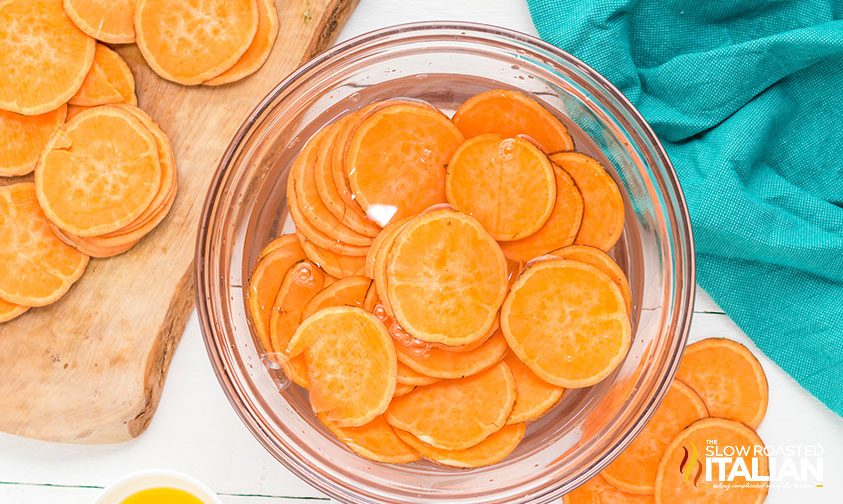sweet potato slices soaking in bowl of water