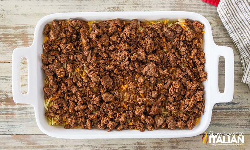 ground beef over rice and cheese in baking dish