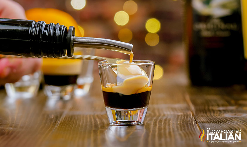 pouring Irish Cream over the back of a spoon into shot glass