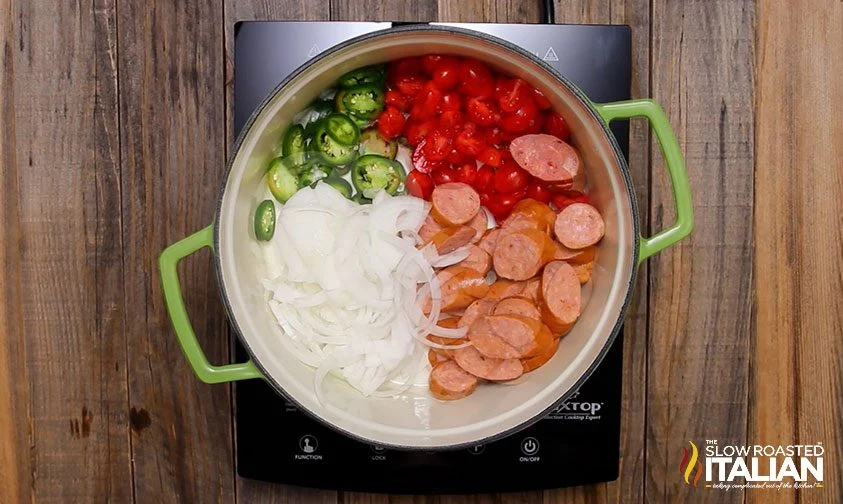 sliced sausage, tomatoes, jalapenos, and onion in a large pot